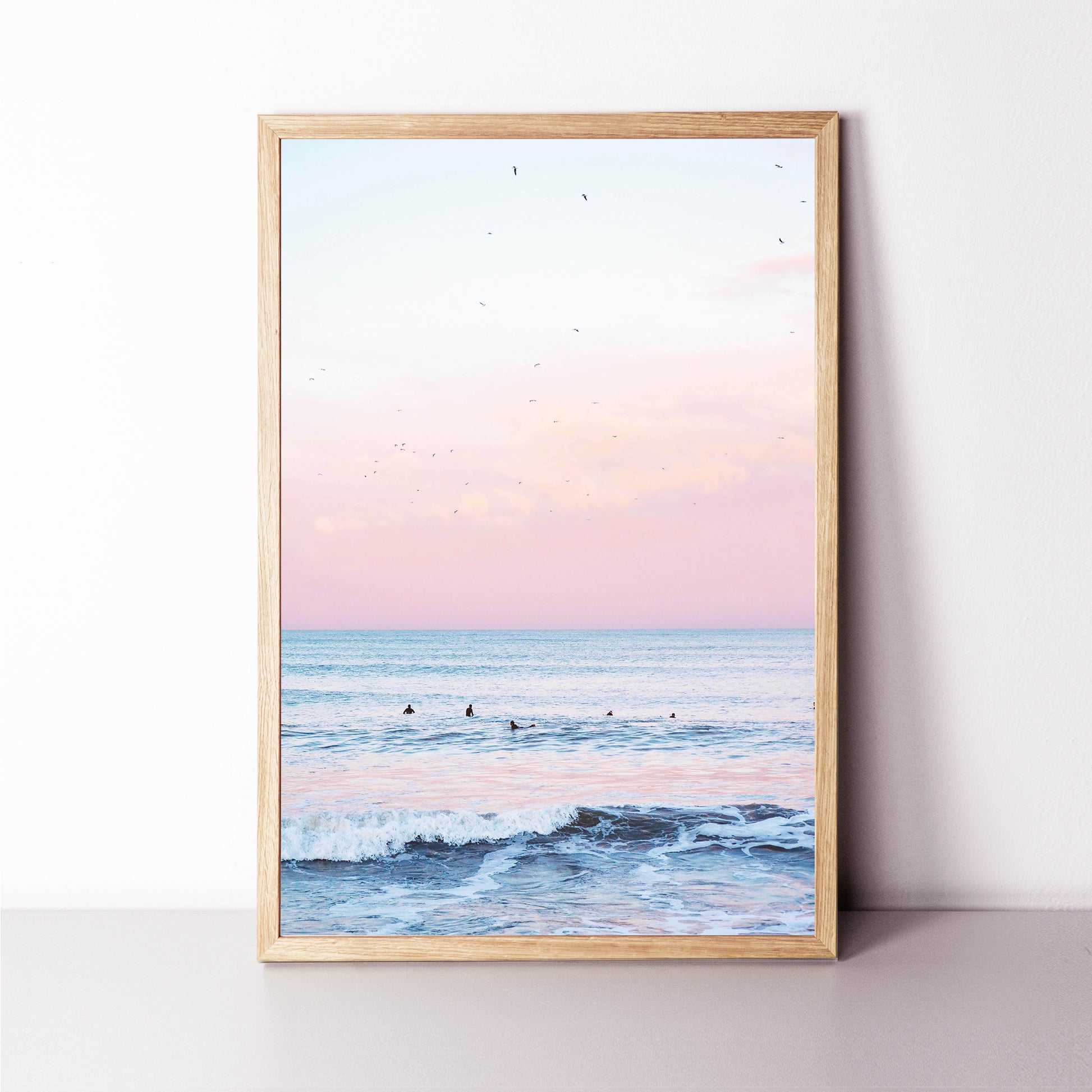 Ocean with surfer print in wood color frame.