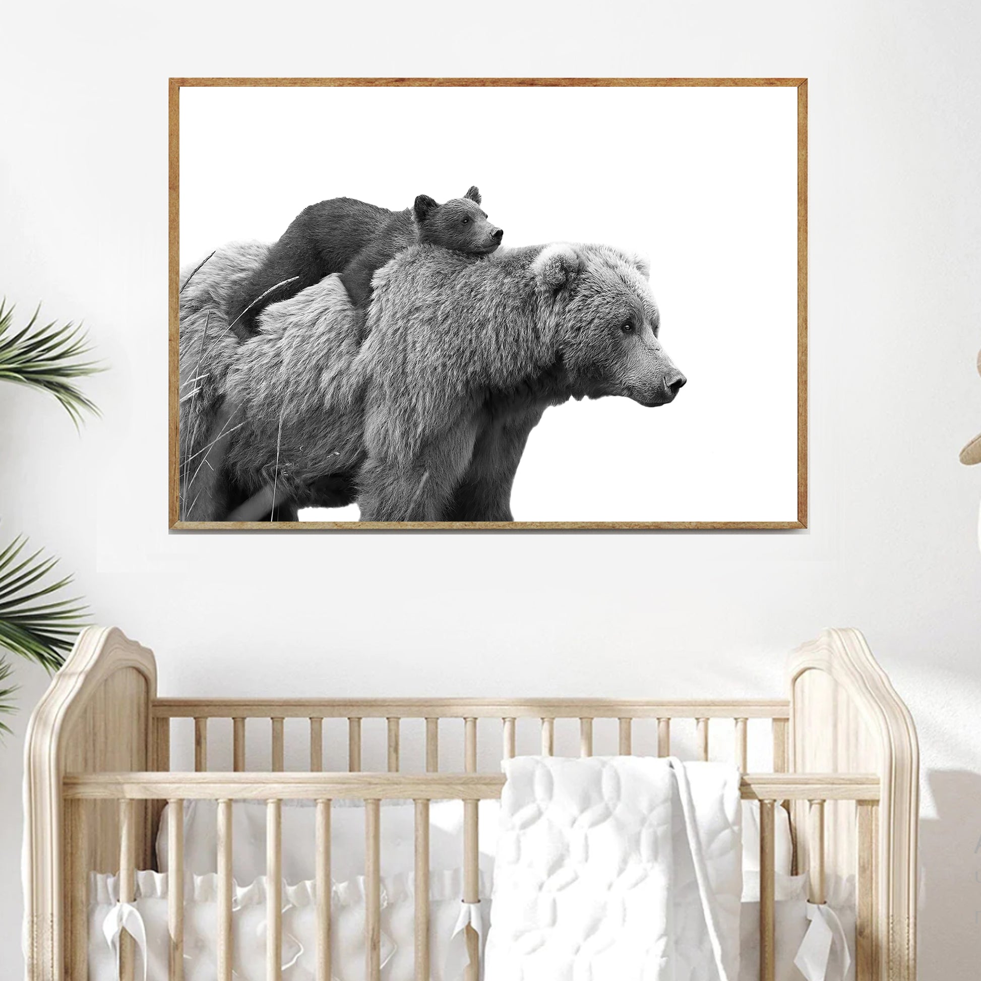 Bear with cub print hanging on the wall above the crib.