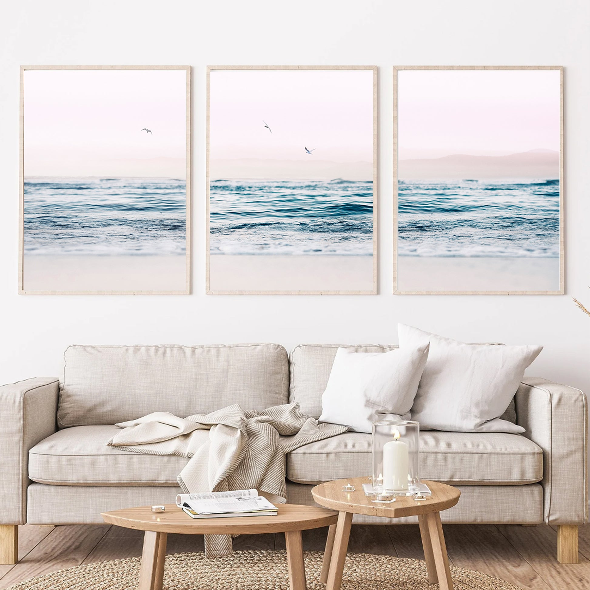 Ocean and seagulls wall art in wood color frames above the sofa.