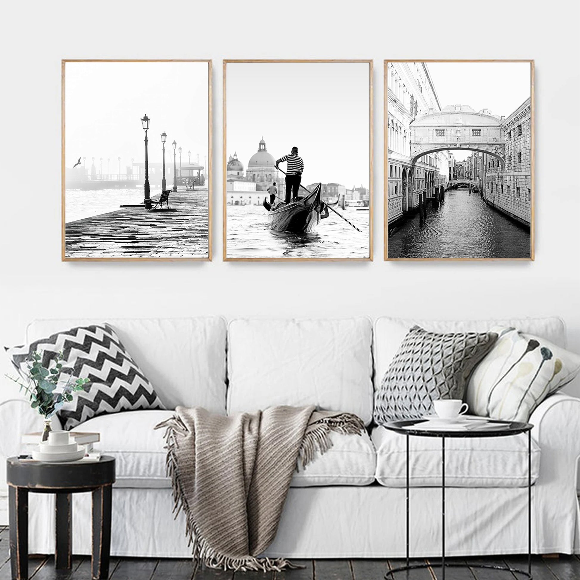 Venice black white photos in wood color frames above the sofa.