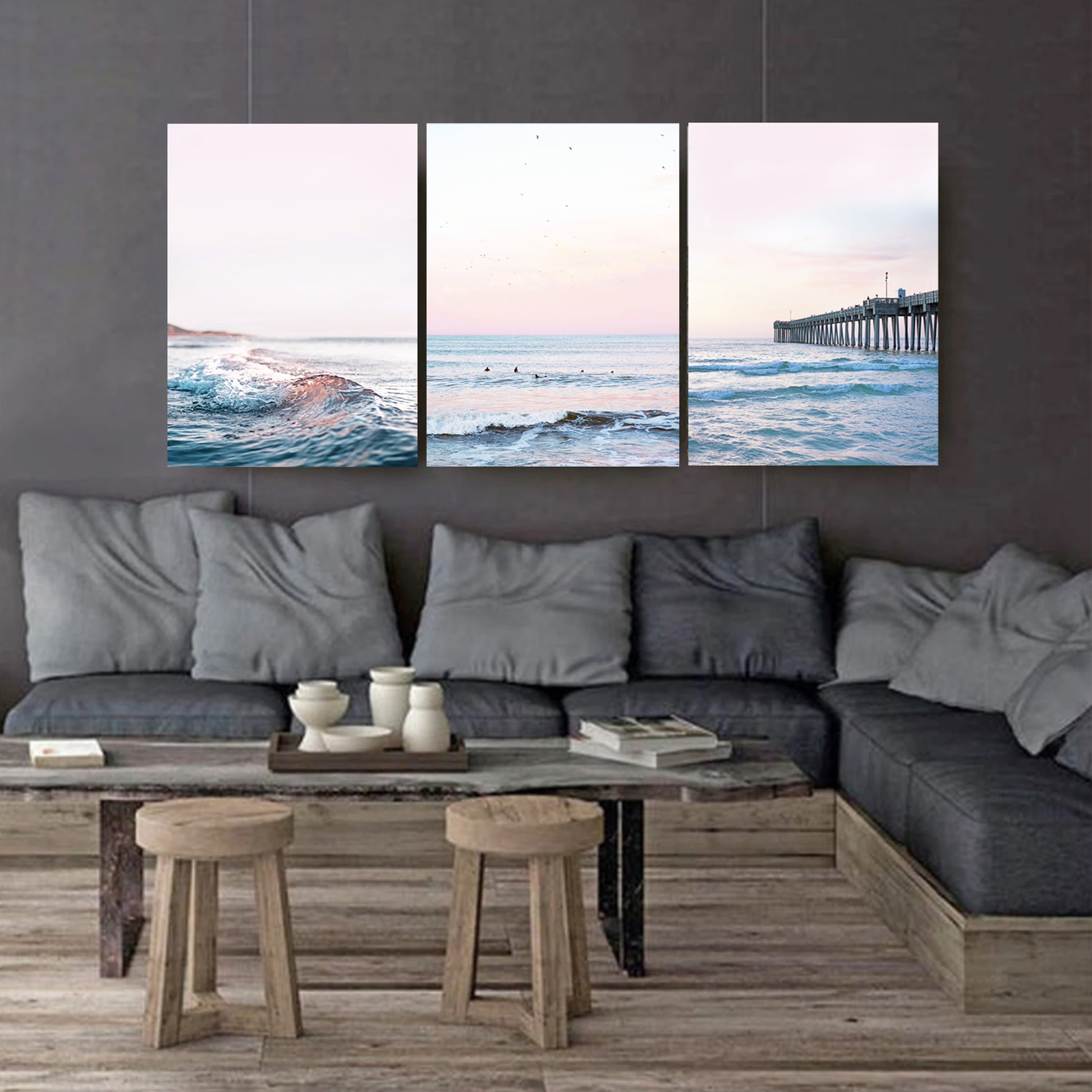 Coastal canvas triptych on dark wall.