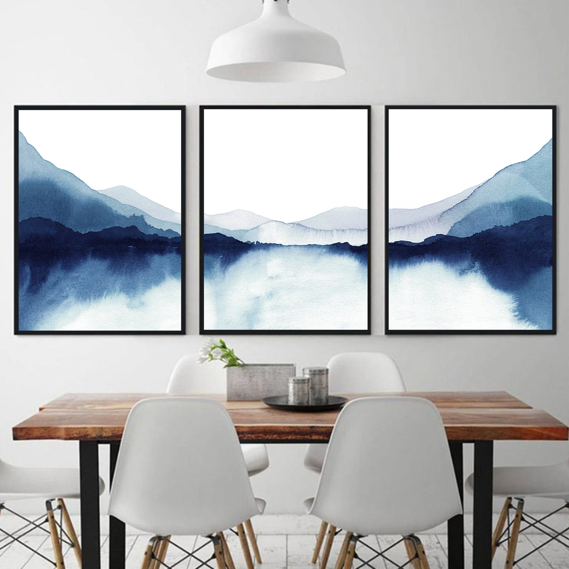 Watercolor lake triptych in black color frames above the desk.