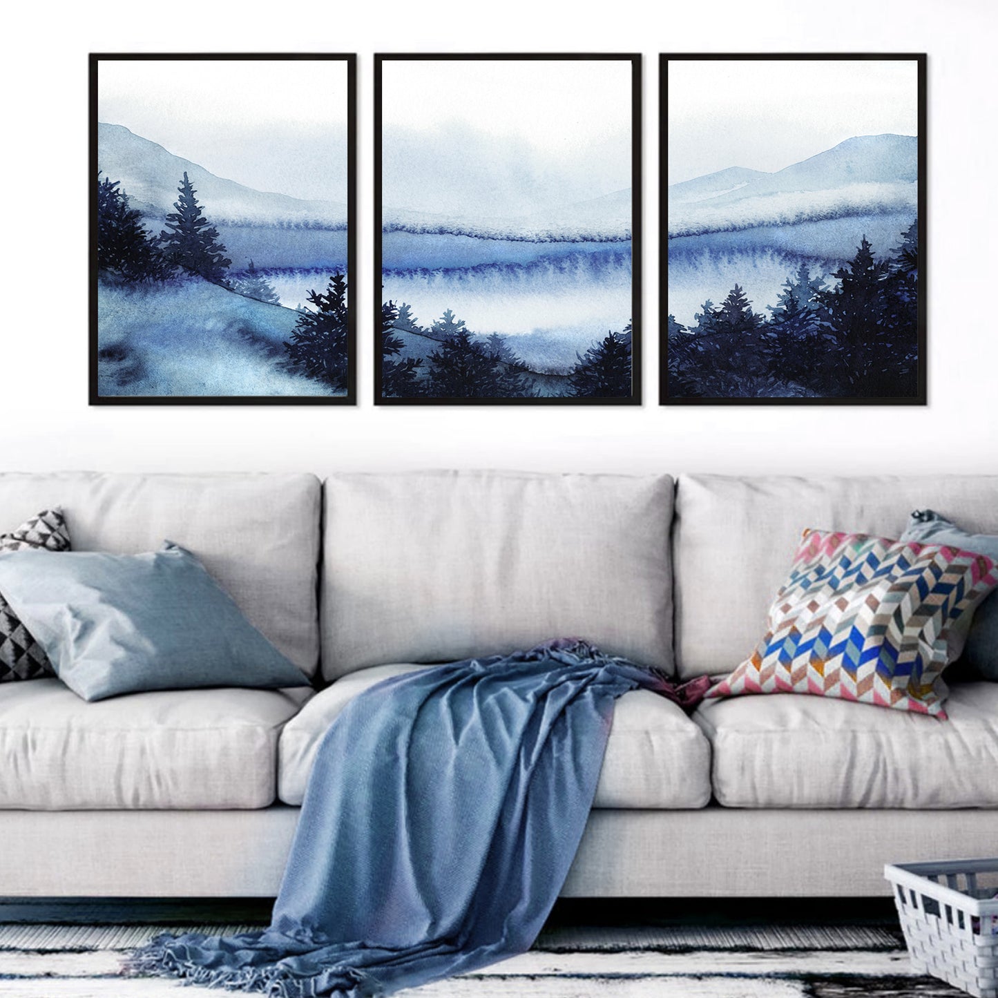 Snowy forest watercolor in black color frames above the sofa.